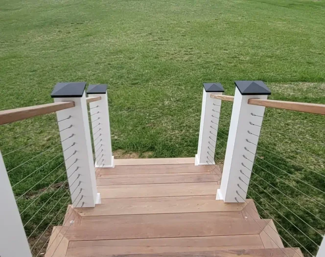 wooden stairs of a white house with grass around